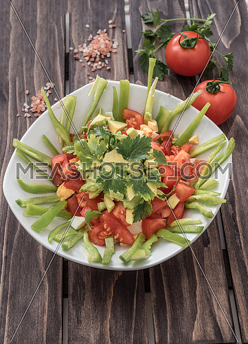 Fresh salad with avocado,tomatoes,lgreen paper and spices