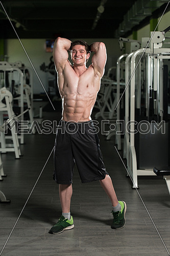 Portrait Of A Young Physically Fit Man Showing His Well Trained Abdominal Muscles - Muscular Athletic Bodybuilder Fitness Model Posing After Exercises