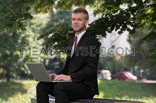 Happy Business Man Using Tablet Pc Outside On A Park Bench