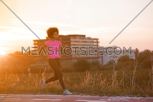 young beautiful African American woman enjoys running outside beautiful summer evening in the city