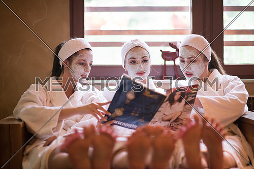 group of famale friends in spa have fun, celebrate bachelorette party with face mask