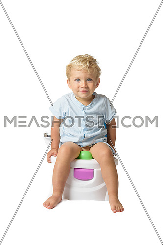 Baby boy, white caucasian smiling and sitting on the potty with white background.