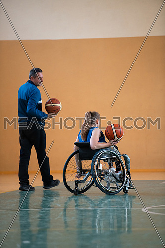 a sports basketball coach explains to a disabled woman in a wheelchair which position to play during a game. High quality photo
