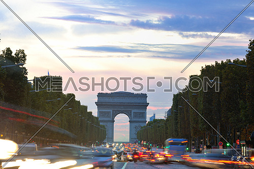 Beautiful night view with car traffic and rush at eavning of the Arc de Triomphe, Paris, France.