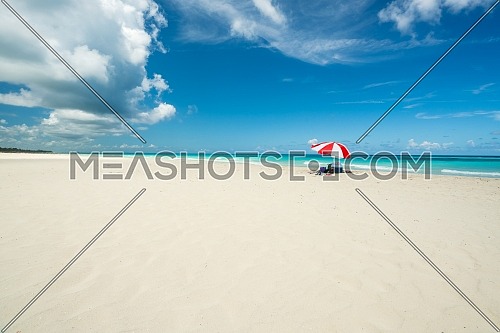 Amazing beach of Varadero during a sunny day, fine white sand and turquoise and green Caribbean sea,on the right one red parasol,Cuba.concept photo,copy space.