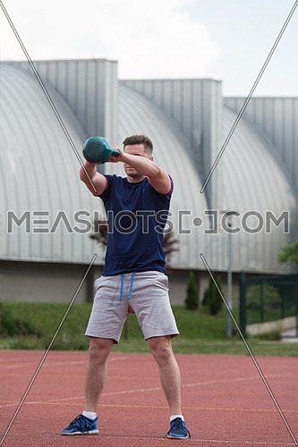 Young Man Working Out With Kettle Bell Exercise Outdoor