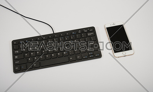 black computer keyboard and mobile phone