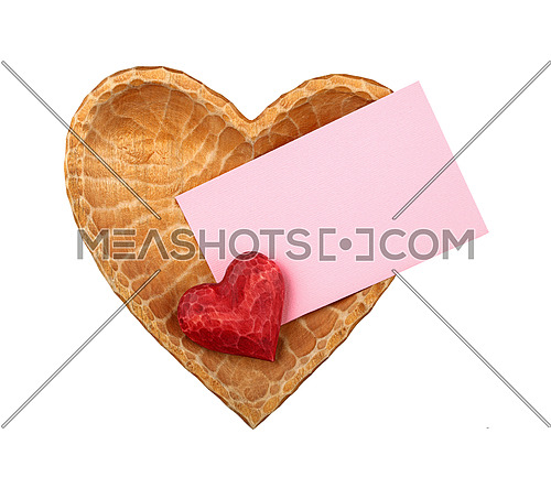 Close up one red painted natural wooden carved heart over pink paper envelope in heart shaped bowl isolated on white background