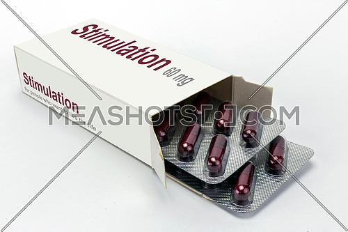 Open medicine packet labelled stimulation opened at one end to display a blister pack of tablets, isolated on white