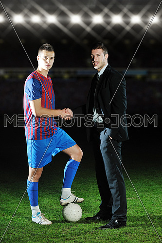 soccer  sport manager in business suit coach and football player on stadium with green grass and white ball