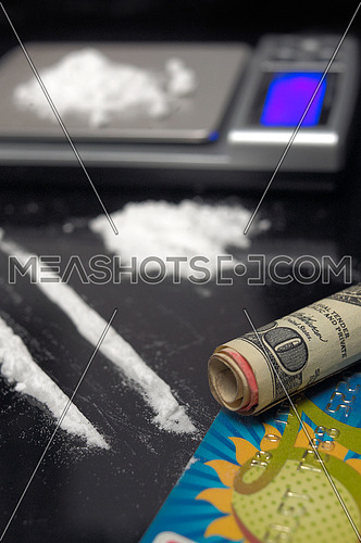 cocaine drug powder over black abuse concept with digital scale over black