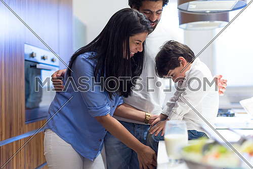 young middle east father and mother with son spend cheerful time in the kitchen