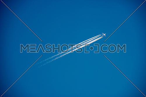 A 4 engine jetliner at cruise altitude with contrails