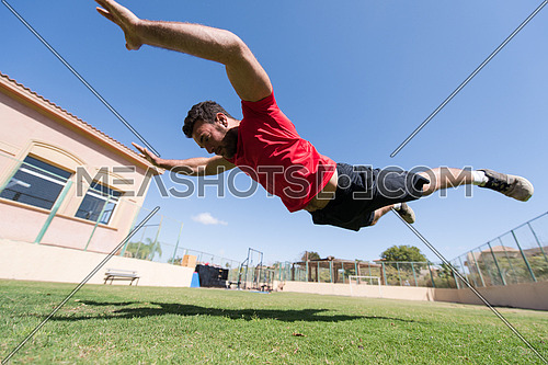 young middle eastern man athlete enjoys doing the extreme push-ups outside