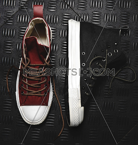 black shoes and red shoes on black metal background