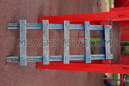 Colored ladder at the playground, bold blue ladder on red amusement park facility