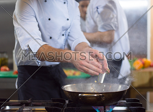Master chef preparing food, frying in wok pan. Sale and food concept