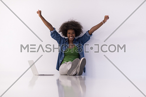 Portrait of happy young african american woman sitting on floor with laptop