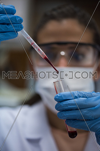 Young middle eastern woman testing blood samples in modern laboratories