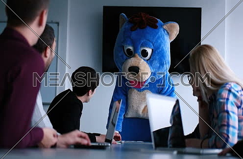 boss dressed as bear having fun with business people in trendy office