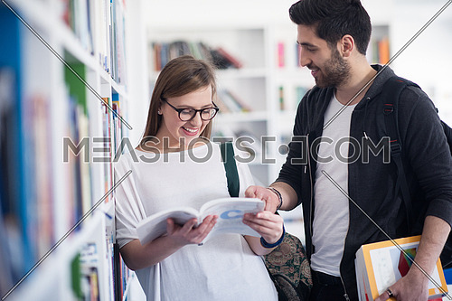 happy students couple in school  library have discussion about book
