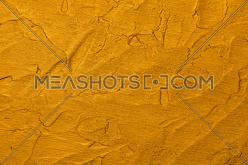 Close up vivid golden yellow abstract background texture of uneven grunge surface with brushstrokes of plaster and paint