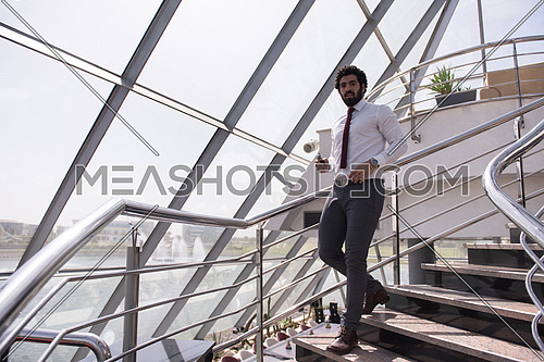 young middle eastern  businessman walking down stairs