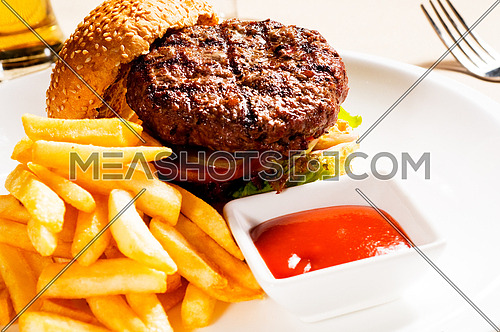 fresh classic american hamburger sandwich with french fries and ketchup sauce on side