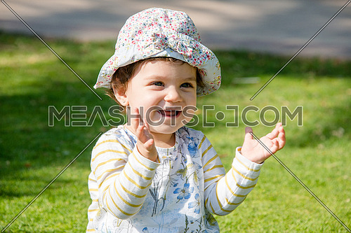 a happy beautiful baby girl in the park