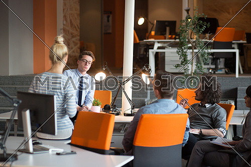 Group of a young business people discussing business plan  in the office