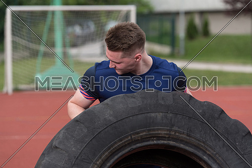 Young Man Turning Tire Over - Bodybuilding Exercises Truck Tire
