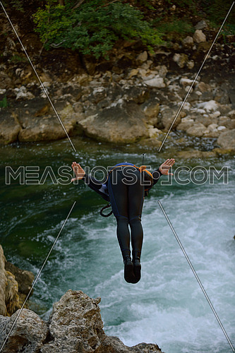 Man jumping in wild river adrenalin sport canyoning
