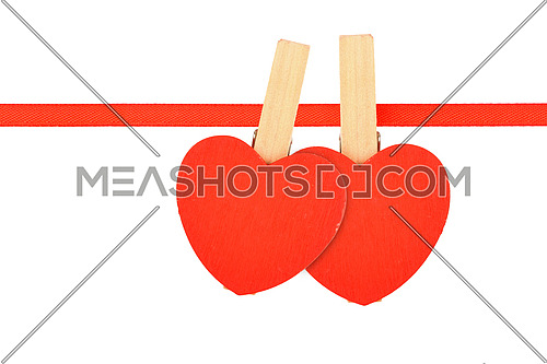 Valentine day love template, two red wooden hearts with clothes pins on textile ribbon isolated on white background