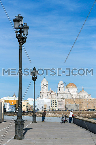 Cadiz, SPAIN -  March 31: Seafront and rail bicycle to the evening, to the fund the cathedral of the holy cross, In cadiz, Andalusia, Spain