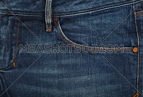Dark indigo blue washed cotton jeans denim texture background with front pocket, close up