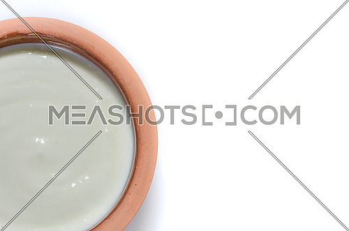 a rounded pottery plate filled with plane yogurt on a white background