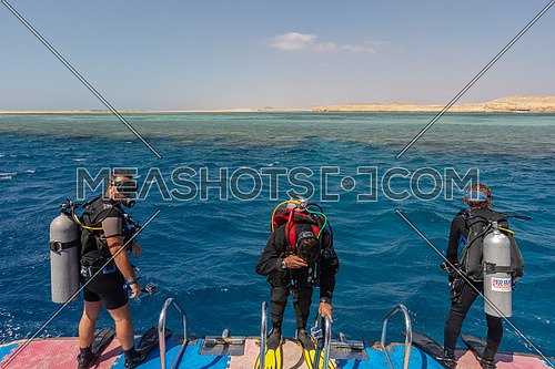 Long shot for divers getting ready to dive into Red Sea from a yacht at day