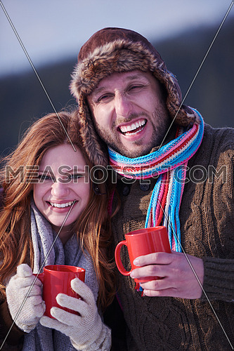portrait of happy young couple outdoor on winter day drinking warm tea