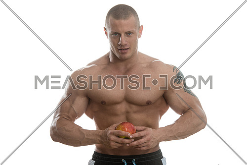 Portrait Of Young Bodybuilder Holding Apple In His Hand - Isolated On White Background