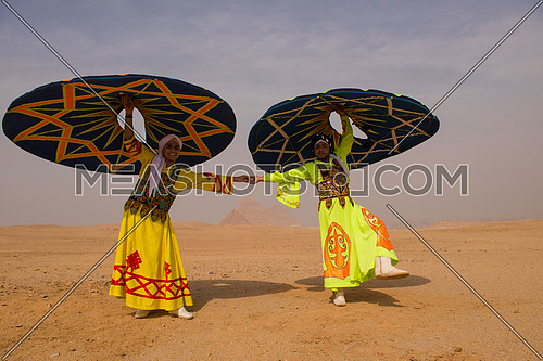 two Egyptian sufi dancers performing at the pyramids