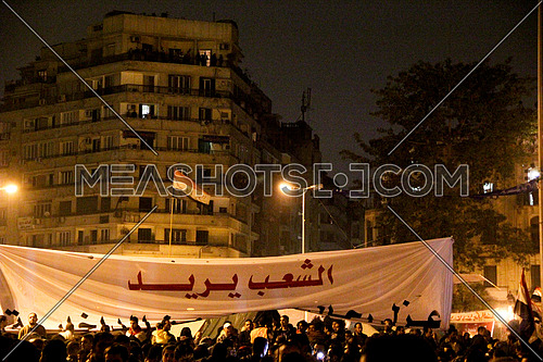 a sign in the middle of tahrir square at night