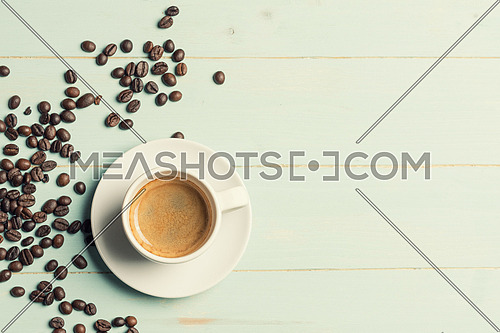 White cup of coffee and coffee bean on green background. Copy space,view from above