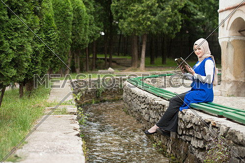 Humble Muslim Woman Is Reading The Koran Outdoors