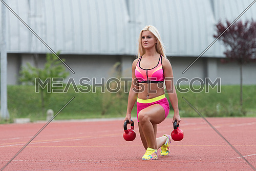 Young Woman Working Out With Kettle Bell Exercise Outdoor