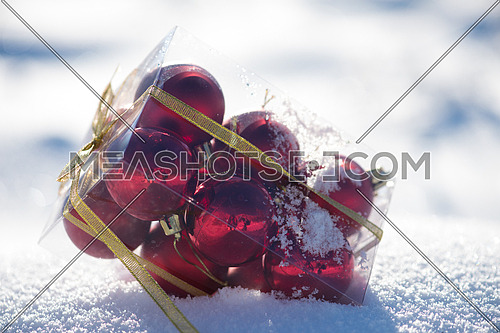 christmas ball in box on fresh  snow at  beautiful sunny winter day