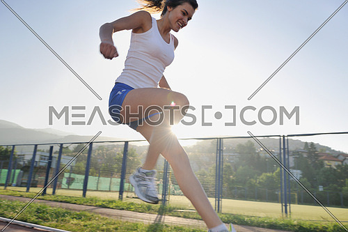 beautiful young woman exercise jogging and runing on athletic track on stadium at sunrise 