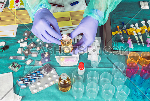 Nurse preparing hospital medication, placing dose medicine in glass monodose, conceptual image, horizontal composition
