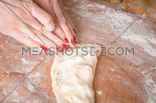 Making dough by female hands brown table background,view from above.