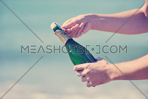 man hands open bottle of champagne alcohol and wine drink outdoor on party celebration event