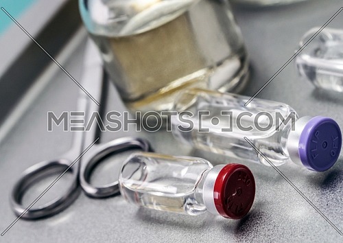 Some vials next to a syringe